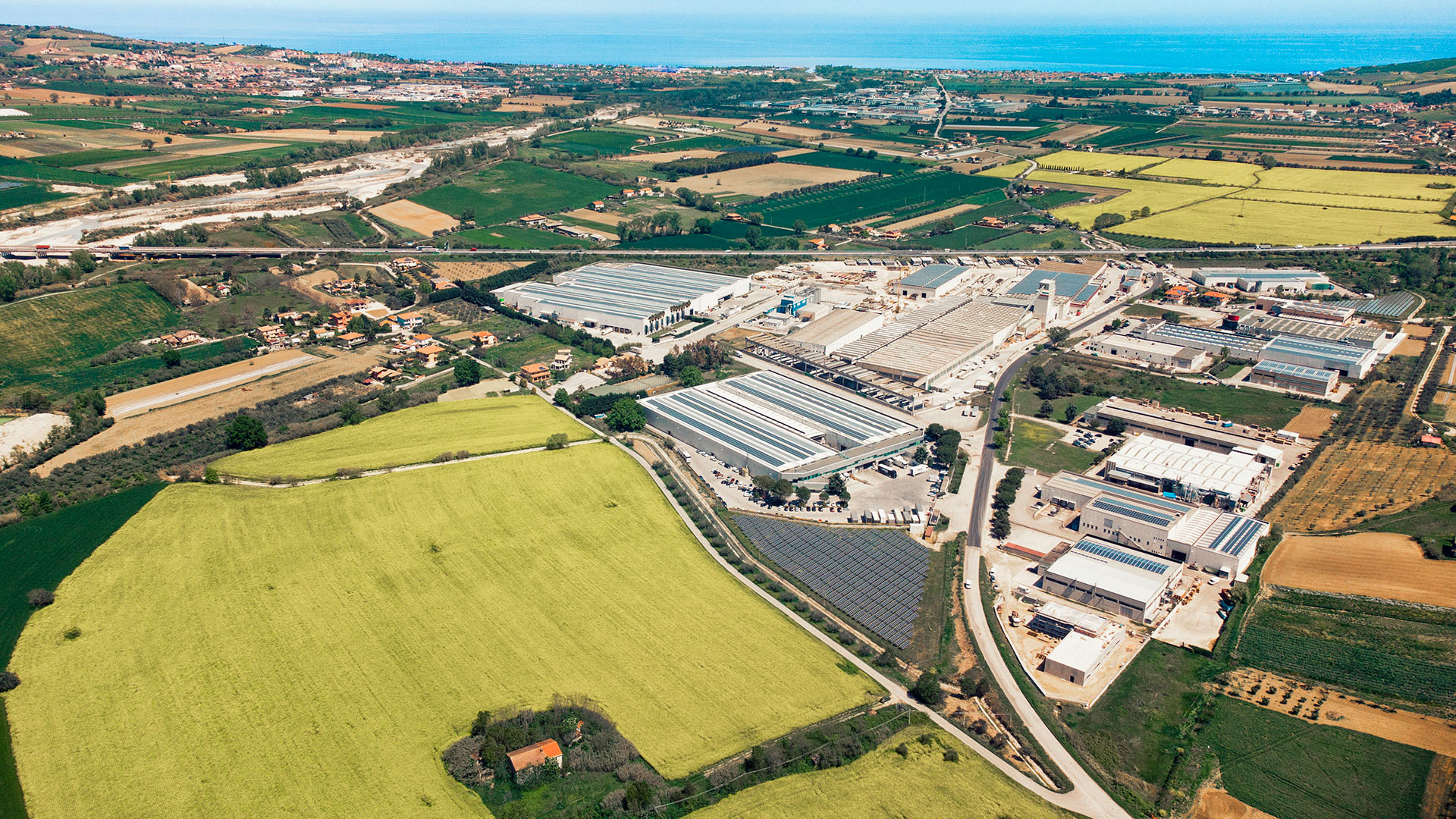 Veduta aerea dello stabilimento Aran World tra i campi, con il mare Adriatico sullo sfondo