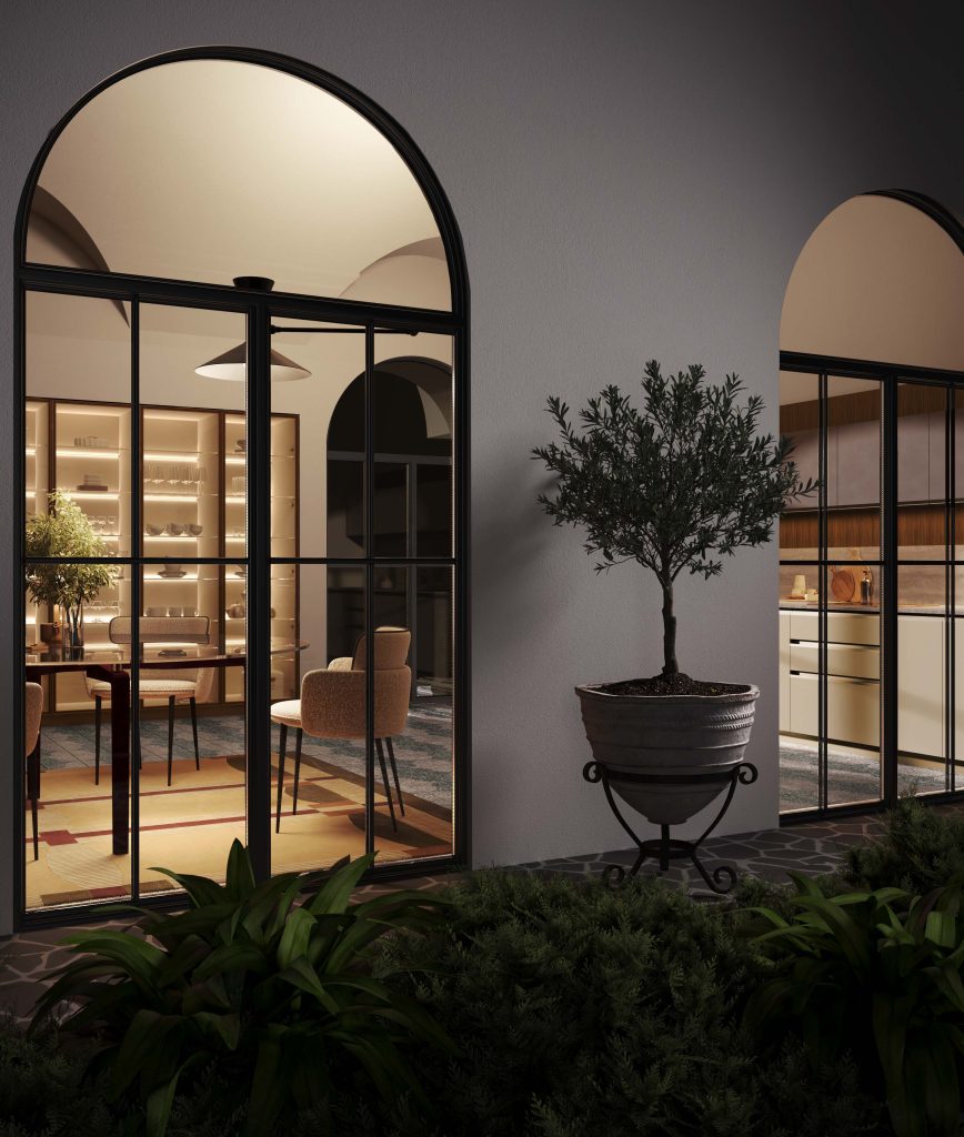 Veduta notturna dalla corte con vetrate ad arco e ulivo, cucina Modern & Design Marilyn di Ciao Cucine illuminata all'interno